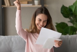 Excited young woman hold paper letter feel euphoric receiving job promotion or tax refund from bank, happy girl reading paperwork document smiling of good pleasant news, getting student scholarship