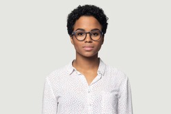 Head shot portrait close up beautiful young African American woman in glasses, businesswoman, student wearing shirt looking at camera, girl with perfect skin, isolated on grey background