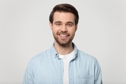 Headshot portrait of happy millennial man in casual clothes isolated on grey studio background posing, smiling young male in shirt look at camera with wide healthy teeth, demonstrated dental treatment