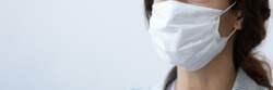 Close up image woman wear medical mask to prevent coronavirus COVID-19 infectious pandemic disease on blue studio background. Horizontal photo banner for website header design with copy space for text