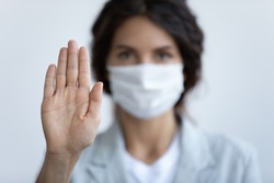 Help stop spreading globally corona virus pandemic infectious disease outbreak. On background woman in mask focus on stretched hand as symbol of keep distance avoid communication, healthcare concept