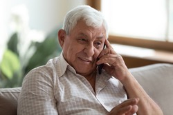 Smiling older man talking on cellphone close up, happy grandfather chatting with relatives or grandchildren, satisfied mature male making or answering phone call, having pleasant conversation