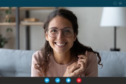 Headshot portrait screen view of smiling millennial woman in glasses sit on couch at home talk on video call with relatives, happy young female have Webcam conversation, take online course indoors
