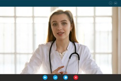 Head shot portrait female doctor wears white coat stethoscope on neck shares latest corona virus warnings by video call provide medical support to client via telecommunications app on pc or smartphone