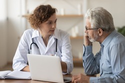 Young female professional doctor physician consulting old male patient, talking to senior adult man client at medical checkup visit. Geriatric diseases treatment. Elderly medical health care concept