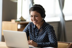 Head shot attractive happy friendly indian woman sitting at desk, holding video call with friends at home. Smiling young mixed race hotline specialist helping customers remotely at workplace.