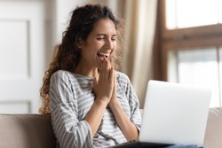 Excited woman looking at laptop screen, rejoicing good news, happy laughing girl reading email or message in social network, win online lottery, great shopping offer, sitting on cozy sofa at home