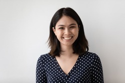 Profile picture of smiling millennial asian girl isolated on grey wall background look at camera posing. Headshot portrait of happy young Vietnamese woman renter or tenant satisfied with service.