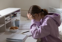 Distressed teen 13s girl pupil feel unmotivated studying alone doing homework at home. Upset unhappy teenage child stressed with school task assignment preparation, have difficulties with learning.