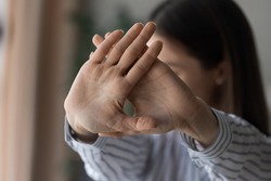 Close up strong confident woman showing stop or defense gesture, saying no, young female protesting against domestic violence, abuse, gender discrimination, nonverbal communication concept