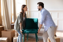 Happy young Caucasian man and woman tenants settle in new modern house or apartment. Smiling millennial couple renters unbox unpack in own home moving relocating together. Rental concept.