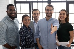 Happy millennial business group leader giving hand for shake. Photo Portrait of diverse professional team welcoming employees for hire and job. Lawyers or brokers offer deal to clients and customers