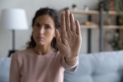 Close up young female show to camera stop gesture sign by outstretched hand. Against of abortion, abuse, domestic violence, hurting women, gender racial discrimination, protest concept, focus on arm