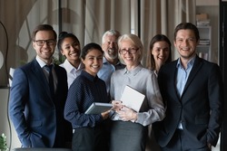Human resource. Group portrait of smiling employees friendly team of diverse age race gender standing in office together. Successful motivated old young age multiethnic corporate staff look at camera