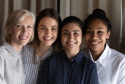 Smiling faces of friendly colleagues. Team portrait of four females coworkers of different age ethnic group. Happy diverse multiethnic women human resource of international company bond look at camera