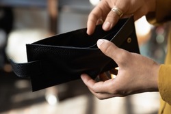 Hands of young African woman opening empty black wallet, leather purse without money. Financial problems, cash crisis, bankruptcy, low income, finance unemployment concept