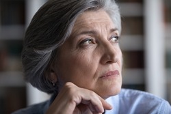 Thoughtful 60s businesswoman staring into distance, close up, take break looks distracted thinks, ponder over issue, search business solution. Older female portrait deep in thoughts, challenge concept