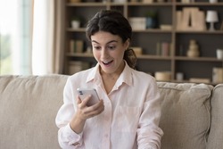 Woman staring at cellphone screen with mouth opened feels happy, read great message, got fantastic commercial proposal, received unbelievable social media news, huge discounts, sale-out offer concept