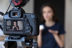 Young beauty blogger girl recording video on dslr camera, shooting post at home for vlog. Vlogger, influencer recording product presentation, filming review for channel. Screen close up