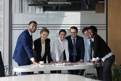 Company professional successful staff members portrait concept. Six multi ethnic young, ambitious employees gather in boardroom, working together take part in seminar meeting smile staring at camera