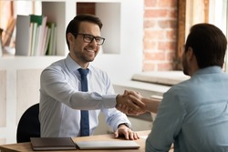 HR manager handshakes company position candidate, selling insurance, professional services. Male entrepreneurs, broker and client shake hands start business meeting in office. Job interview concept