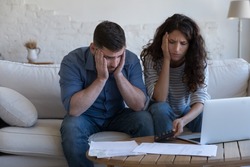 Concerned upset millennial couple counting overspent budget, doing paperwork, thinking on financial problems, high mortgage, rental fees, bad loan conditions, bankruptcy, eviction notice