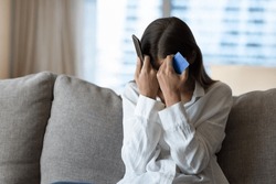 Desperate frustrated bank client woman facing scam, overspending, problems with online payments, blocked credit card, bankruptcy, holding smartphone, touching head, covering face