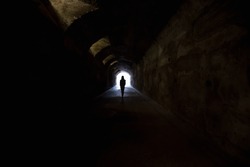 Person in dark tunnel, going towards the light. 