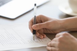 Businesswoman signing document concept, focus on female hand holding pen, putting signature on legal document, giving permission by authorization, subscribing contract, binding agreement, close up