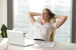 Calm smiling businesswoman relaxing at comfortable office chair hands behind head, happy woman resting in office satisfied after work done, enjoying break with eyes closed, peace of mind, no stress