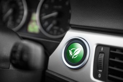 Green ECO mode button on a dashboard of a sportive car.