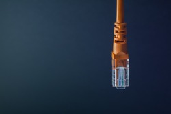LAN connection orange plastic connector isolated on black background