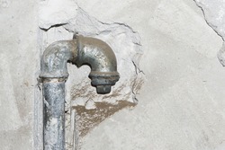 Metal water pipe. Old house plumbing system background. Grunge rusty steel pipe. Iron piping in the wall. Plumber background. Empty copy space pipe. Closeup pipeline. Bathroom renovation background.