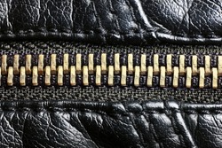 Metal zipper background. Black leather jacket. Autumn and winter fashion texture. Closed fastener. Zipped zipper. Fabric design pattern. Closeup clothing zipper.