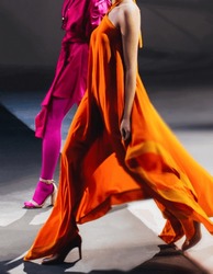 Fashion models woman wearing bright long orange pink summer dress. Casual stylish female clothes concept. Fashion week catwalk fashion details