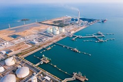 Aerial view of Oil refinery and Modern sea harbor with transhipment equipment for oil tankers, oil production plant. Crude oil tanker and Gas lpg tanker container ship, coal powered electricity plant