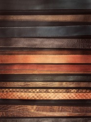 Leather textured background - stripes of the straps in classic style. Trendy accessories as backdrop for vertical billboard or fashion magazine cover. Leather belts as horizontal lines for your text.