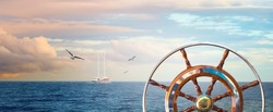 Marine landscape with a steering wheel and sailing yacht on skyline. Calm sea with a cloudy sky at sunrise and flying seagulls for your concept about romantic sea voyage on a ship around the world.