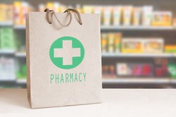 Recycled paper bag with a green Pharmacy logo in a drugstore. Empty copy space for Editor's content..