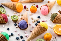 Colorful ice cream cone on a white table, different flavor ice creams with cone. Asorted of ice cream scoops. Colorful set of ice cream scoops of different flavours