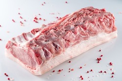 raw pork brisket on the rib, pork brisket on a bone. A piece of raw meat on a white background.