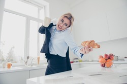 Adorable busy attractive charming beautiful smiling lady office executive worker wearing spectacles in hurry early in the morning talking on the phone having a drink and croissant in kitchen