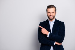 Portrait of cheerful excited joyful satisfied handsome attractive fashionable macho guy dressed in formal outfit dark velvet pointing on empty blank copyspace isolated on gray background copy-space