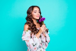 Profile side view photo of lovely, brunette young woman hold small bouquet of summer flowers in hand and breathe in their smell isolated on shine teal background stand half a turn