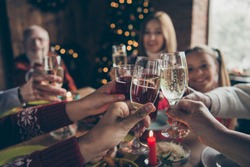Eve family gathering meeting dream wish concept. Cropped wineglass, cheerful gray-haired grandparents, grandchildren, daughter sitting at table, house party, fun joy navidad hands hold glass