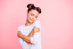 Portrait of nice-looking sweet lovable attractive winsome fascinating well-groomed lovely calm peaceful cheery girl hugging herself isolated over pink pastel background