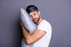 Close-up portrait of his he nice attractive bearded guy holding in hands pillow drowsiness going to bed sleeping quietly calmly isolated over gray pastel violet purple background
