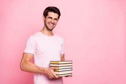 Portrait of his he nice attractive content confident diligent cheerful cheery glad positive intelligent guy holding in hands carrying book library isolated over pink pastel background