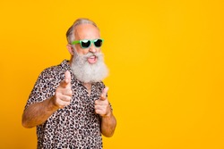 Hey you! Portrait of funky old bearded man in eyeglasses eyewear  feel cool crazy point at you  wearing leopard shirt isolated over yellow background