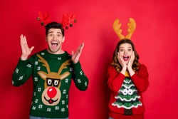 Portrait of amazed excited two people family wife husband brunet hair scream wow omg hear  news  wear season christmas tree hipster pattern pullover sweater isolated over red color background